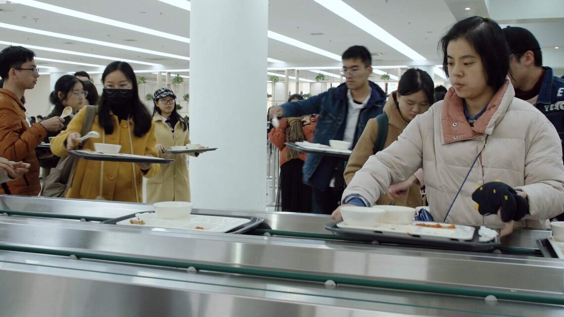 Students place their trays on a conveyor in the canteen when they have finished eating